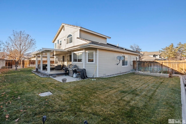 back of property with a lawn and a patio area