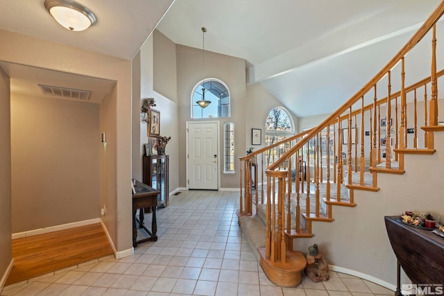 tiled entryway with lofted ceiling