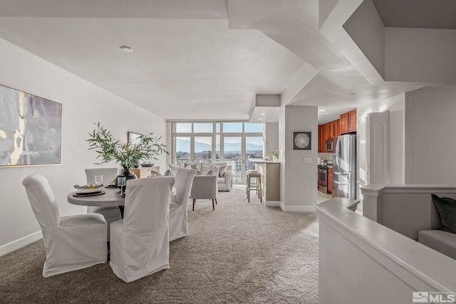 dining space featuring light carpet and expansive windows