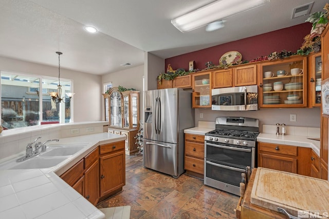 kitchen featuring a chandelier, decorative light fixtures, stainless steel appliances, and sink