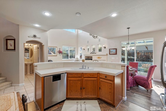 kitchen featuring sink, decorative light fixtures, stainless steel dishwasher, an island with sink, and a notable chandelier