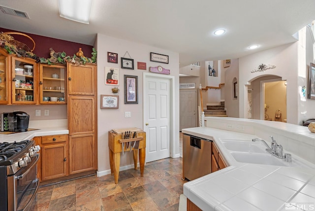 kitchen with tile counters, sink, and stainless steel appliances