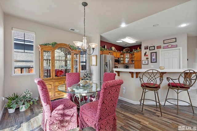 dining space featuring dark hardwood / wood-style flooring and a chandelier