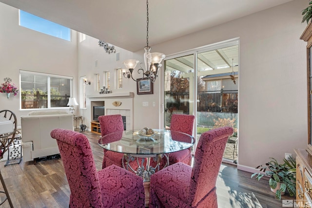 dining room with a fireplace, dark hardwood / wood-style flooring, and an inviting chandelier