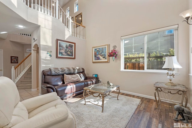 living room with dark wood-type flooring and a high ceiling