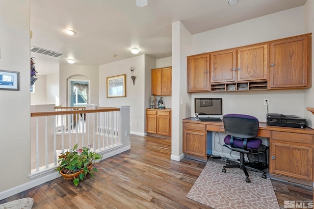 office with built in desk and wood-type flooring