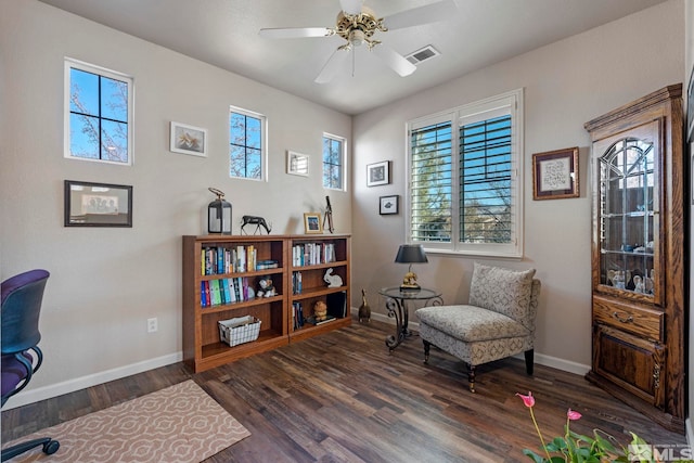 living area featuring ceiling fan and dark wood-type flooring