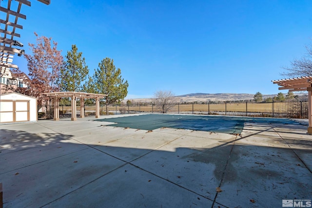 view of pool featuring a pergola, a patio area, and a mountain view