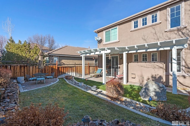 rear view of house with a pergola, a patio area, and a lawn