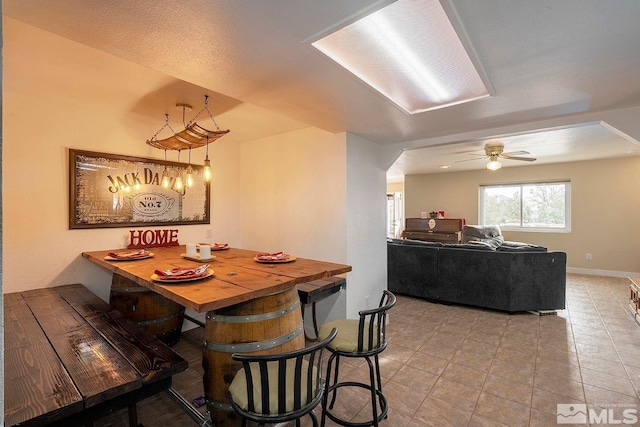 dining space with ceiling fan, light tile patterned floors, and a textured ceiling