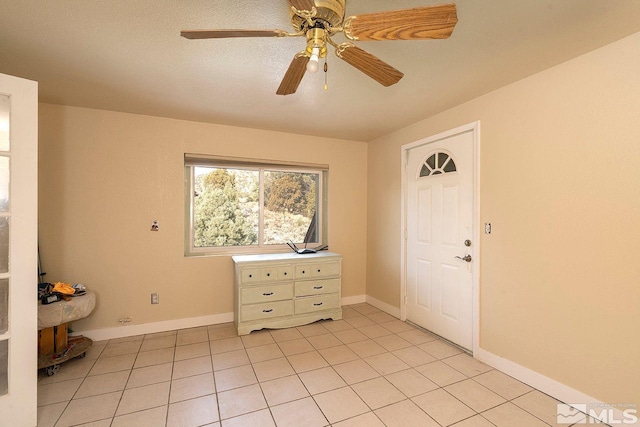 interior space with light tile patterned floors, a textured ceiling, and ceiling fan