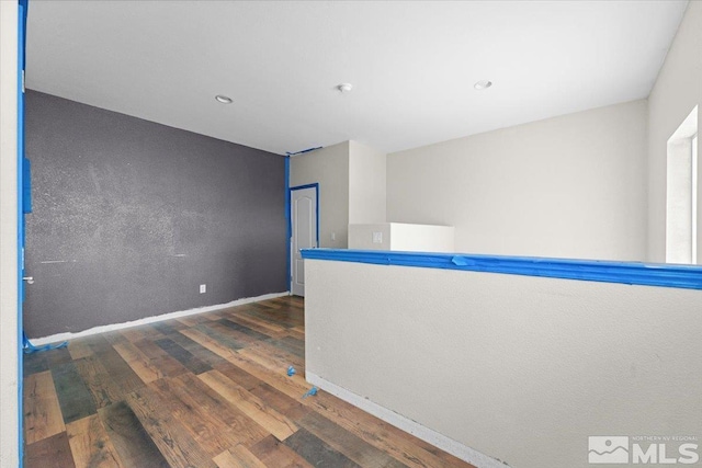 unfurnished room featuring recessed lighting, baseboards, and wood finished floors
