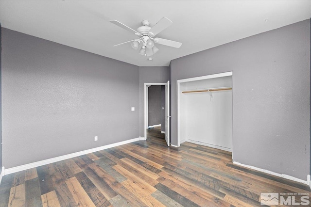 unfurnished bedroom featuring a ceiling fan, baseboards, wood finished floors, and a closet
