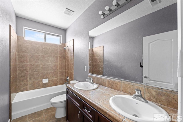 bathroom with a sink, a textured wall, and visible vents