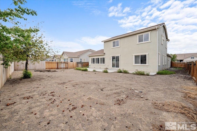 back of house with a fenced backyard, stucco siding, and a residential view