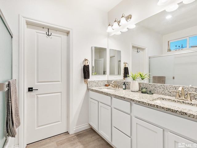 bathroom with vanity, an enclosed shower, and hardwood / wood-style flooring