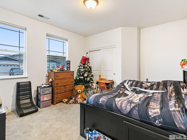 bedroom featuring light carpet and a closet