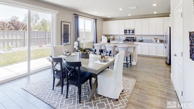 dining space with light wood-type flooring and sink