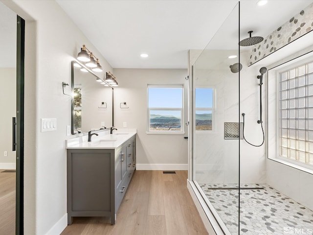 bathroom featuring a tile shower, vanity, and hardwood / wood-style flooring