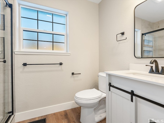 bathroom with vanity, hardwood / wood-style flooring, toilet, and an enclosed shower