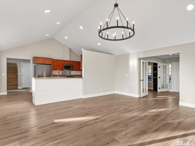 unfurnished living room with french doors, dark hardwood / wood-style flooring, and an inviting chandelier