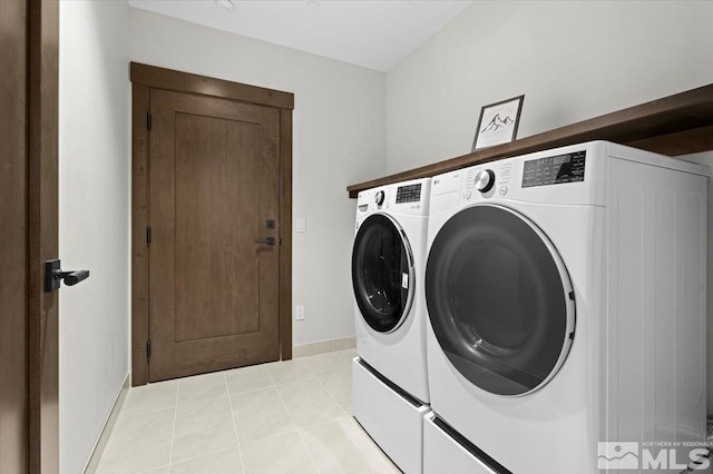 laundry area featuring washer and clothes dryer and light tile patterned flooring