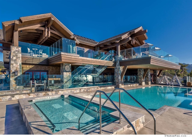 view of swimming pool with a hot tub