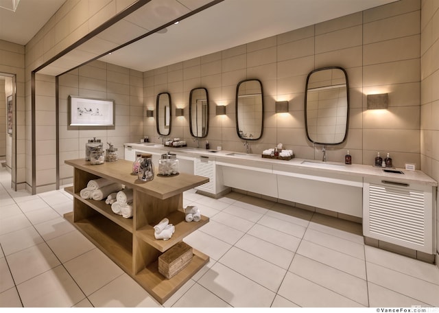 bathroom with tile patterned flooring, vanity, tasteful backsplash, and tile walls