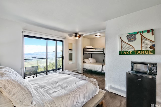 bedroom featuring dark hardwood / wood-style floors, ceiling fan, and baseboard heating