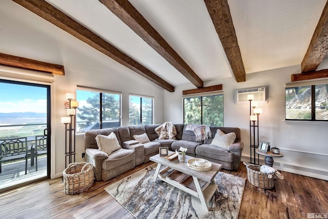 living room featuring a wall unit AC, vaulted ceiling with beams, and light hardwood / wood-style flooring