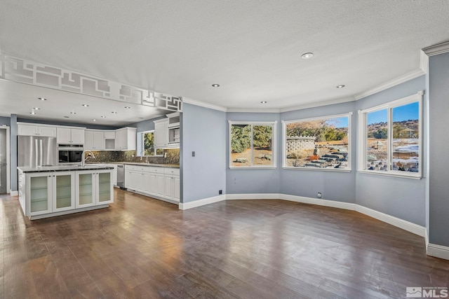 kitchen with a center island, white cabinets, dark hardwood / wood-style floors, and appliances with stainless steel finishes