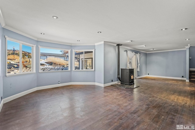 unfurnished living room with a wood stove, hardwood / wood-style floors, a textured ceiling, and ornamental molding