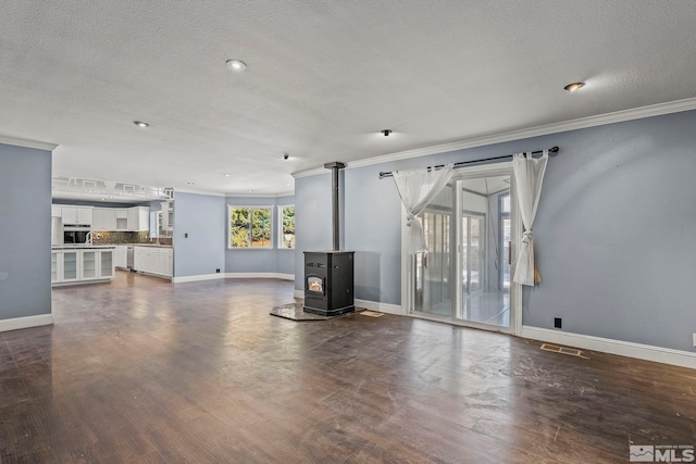 unfurnished living room with a textured ceiling, a wood stove, dark wood-type flooring, and crown molding