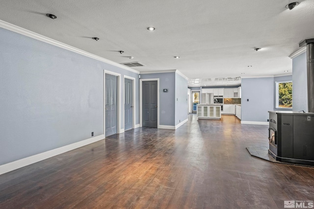 unfurnished living room featuring a textured ceiling, dark hardwood / wood-style floors, a wood stove, and ornamental molding