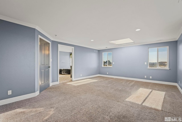 spare room featuring carpet floors, crown molding, and a wealth of natural light