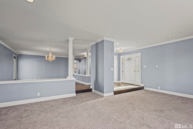 spare room with carpet, decorative columns, an inviting chandelier, and crown molding