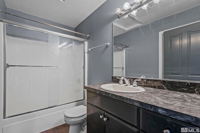 full bathroom featuring combined bath / shower with glass door, vanity, and toilet