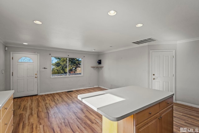 kitchen with hardwood / wood-style flooring, a center island, and ornamental molding