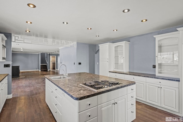 kitchen with dark hardwood / wood-style flooring, a kitchen island with sink, sink, white electric cooktop, and white cabinetry