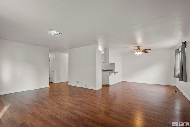 unfurnished living room with ceiling fan and dark wood-type flooring