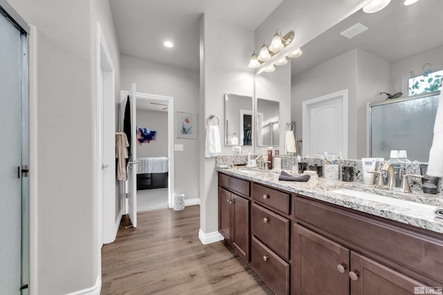 bathroom with hardwood / wood-style flooring, vanity, and an enclosed shower