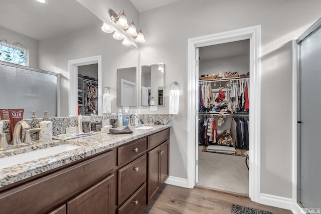 bathroom with vanity, hardwood / wood-style flooring, and walk in shower