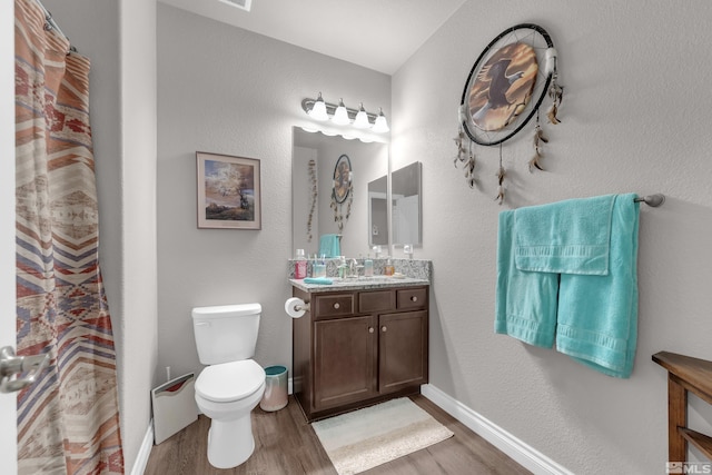 bathroom with hardwood / wood-style floors, vanity, and toilet