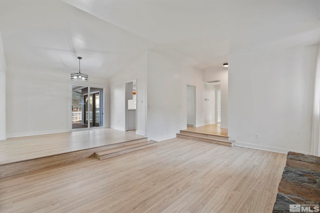 unfurnished living room with vaulted ceiling and light hardwood / wood-style flooring