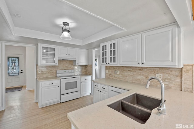 kitchen with white cabinetry, sink, hanging light fixtures, white appliances, and a tray ceiling