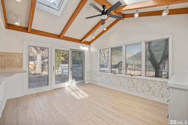 interior space featuring lofted ceiling with skylight and ceiling fan