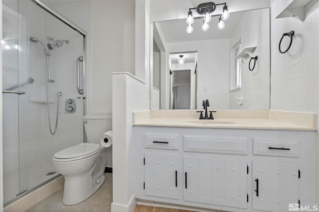 bathroom featuring toilet, vanity, tile patterned floors, and walk in shower