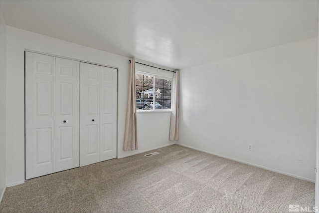 unfurnished bedroom featuring a closet and carpet floors