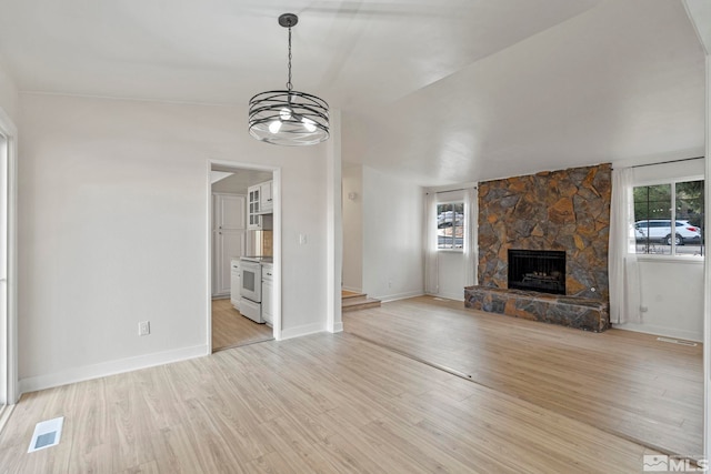 unfurnished living room featuring a healthy amount of sunlight, light wood-type flooring, and a fireplace