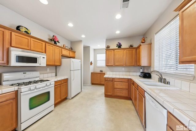 kitchen with tile countertops, sink, and white appliances